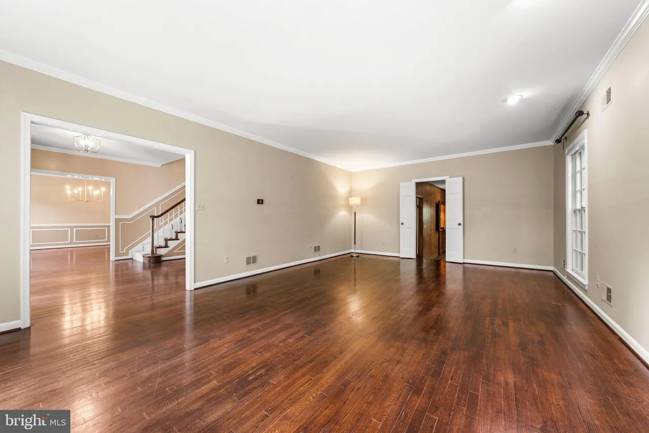 Empty living room before decorating — hardwood floors, natural light, blank walls